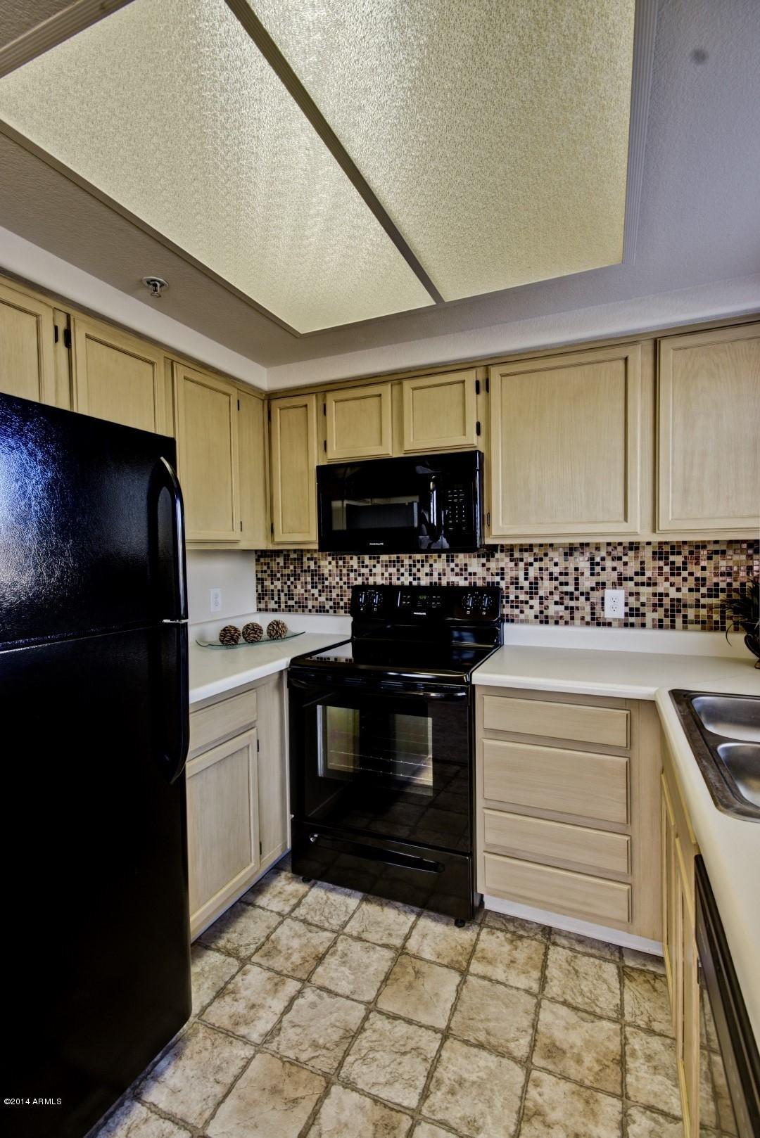 1825 West Ray Road, Unit 2055 Chandler, AZ 85224 - Photo 10 of 28 a kitchen with a sink and a stove top oven