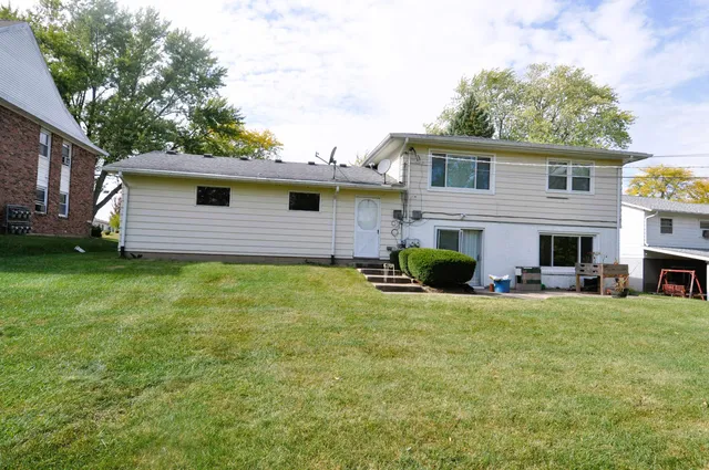 a view of a house with a backyard and a tree