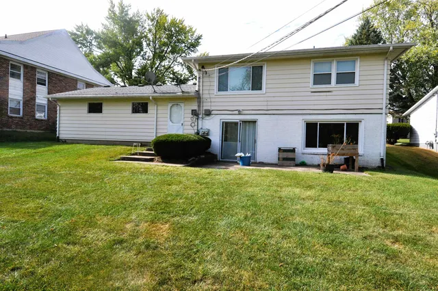 a view of a house with backyard and sitting area