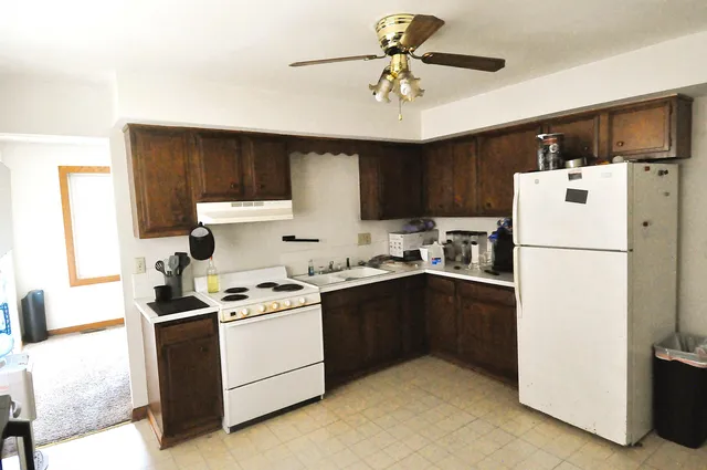 a kitchen with a sink a refrigerator and cabinets