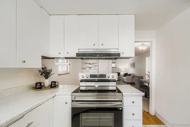 a kitchen with a stove and a white cabinets