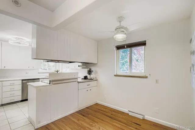 a kitchen with stainless steel appliances a sink cabinets and wooden floor
