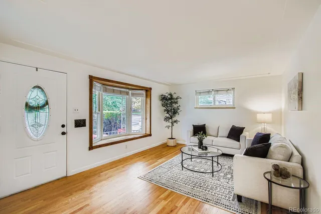 a living room with furniture a window and wooden floor