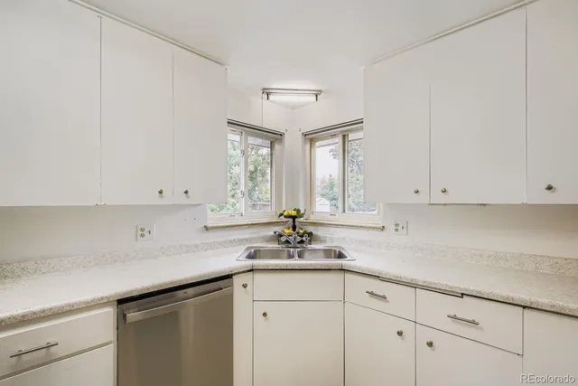 a kitchen with white cabinets and a window