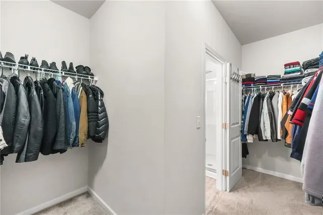 a view of walk in closet with clothes and shoes