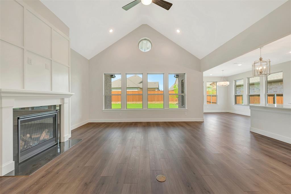 11460 Wulstone Road Fort Worth, TX 76052 - Photo 5 of 40 an empty room with wooden floor fireplace and windows