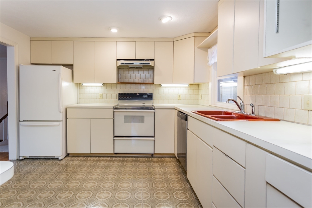 89 Jackson Drive Raynham, MA 02767 - Photo 14 of 30 a kitchen with white cabinets and white appliances
