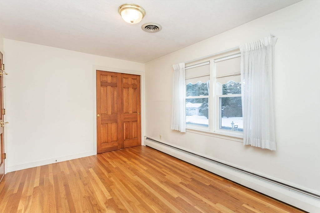 89 Jackson Drive Raynham, MA 02767 - Photo 18 of 30 an empty room with wooden floor and windows
