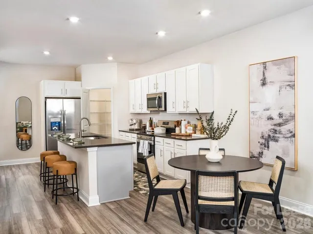 a kitchen with sink a table and chairs in it