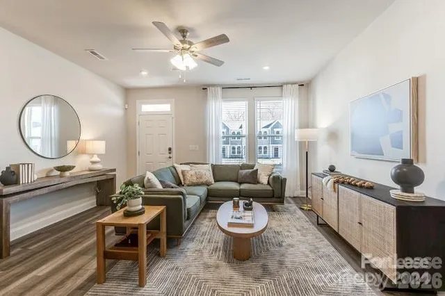 a living room with furniture flat screen tv and a large window
