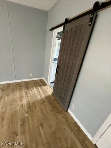 an empty room with wooden floor and entrance