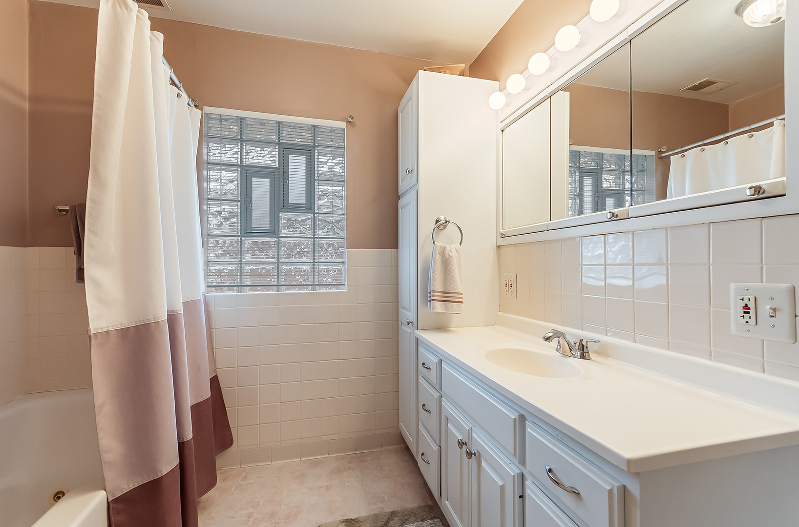 409 Cornelia Street Joliet, IL 60435 - Photo 18 of 27 a bathroom with a sink a mirror and a shower