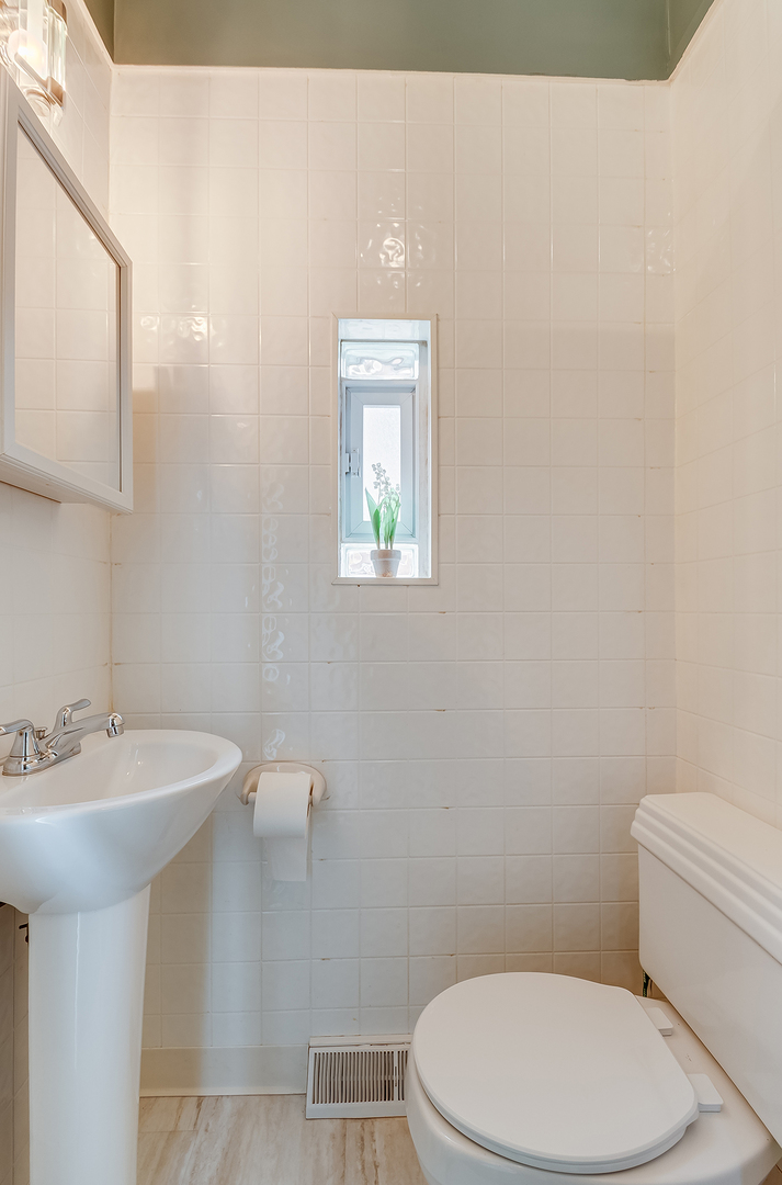 409 Cornelia Street Joliet, IL 60435 - Photo 10 of 27 a bathroom with a toilet a sink and mirror