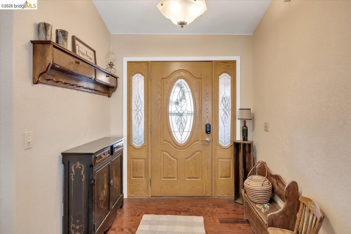 14450 Jacksonville Road Jamestown, CA 95327 - Photo 14 of 85 Wood-finish flooring, a light wood entry door with oval leaded glass, and two frosted glass sidelights