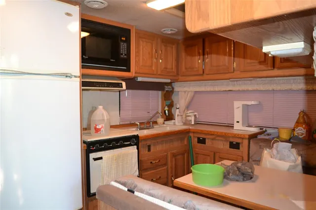 a kitchen with stainless steel appliances granite countertop a refrigerator and a stove top oven