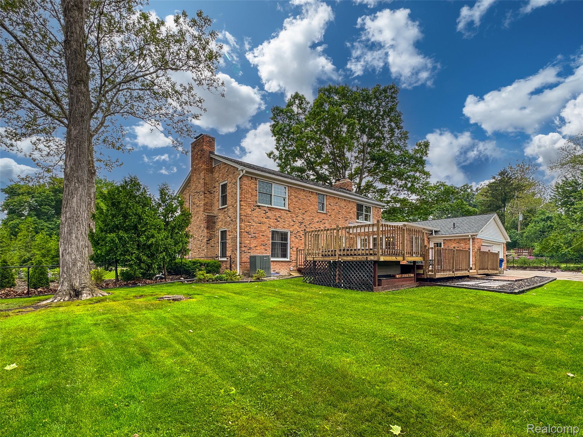 100 Overhill Road Bloomfield Hills, MI 48301 - Photo 41 of 55 Rear view of house featuring a chimney, a yard, a wooden deck, and brick siding