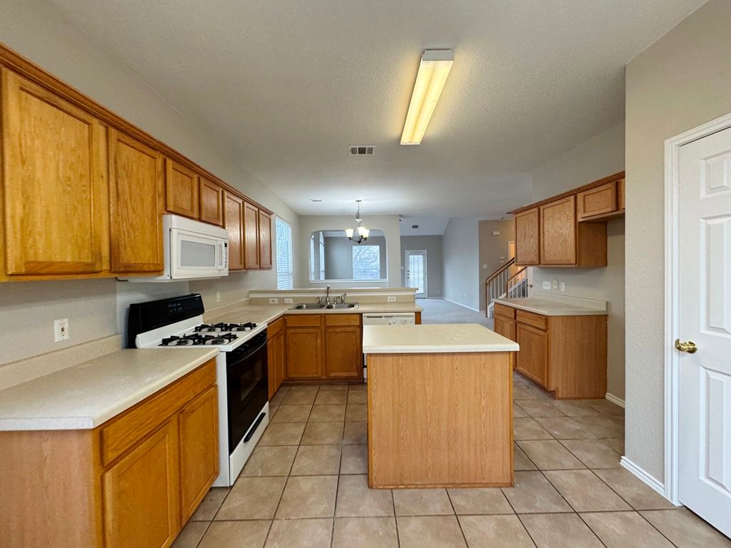 544 Hogan Kyle, TX 78640 - Photo 12 of 40 a kitchen with a stove top oven sink and cabinets