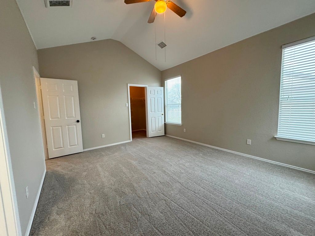 544 Hogan Kyle, TX 78640 - Photo 21 of 40 an empty room with windows and chandelier fan