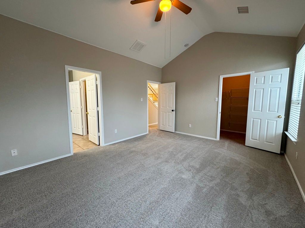 544 Hogan Kyle, TX 78640 - Photo 22 of 40 an empty room with a chandelier fan and a window