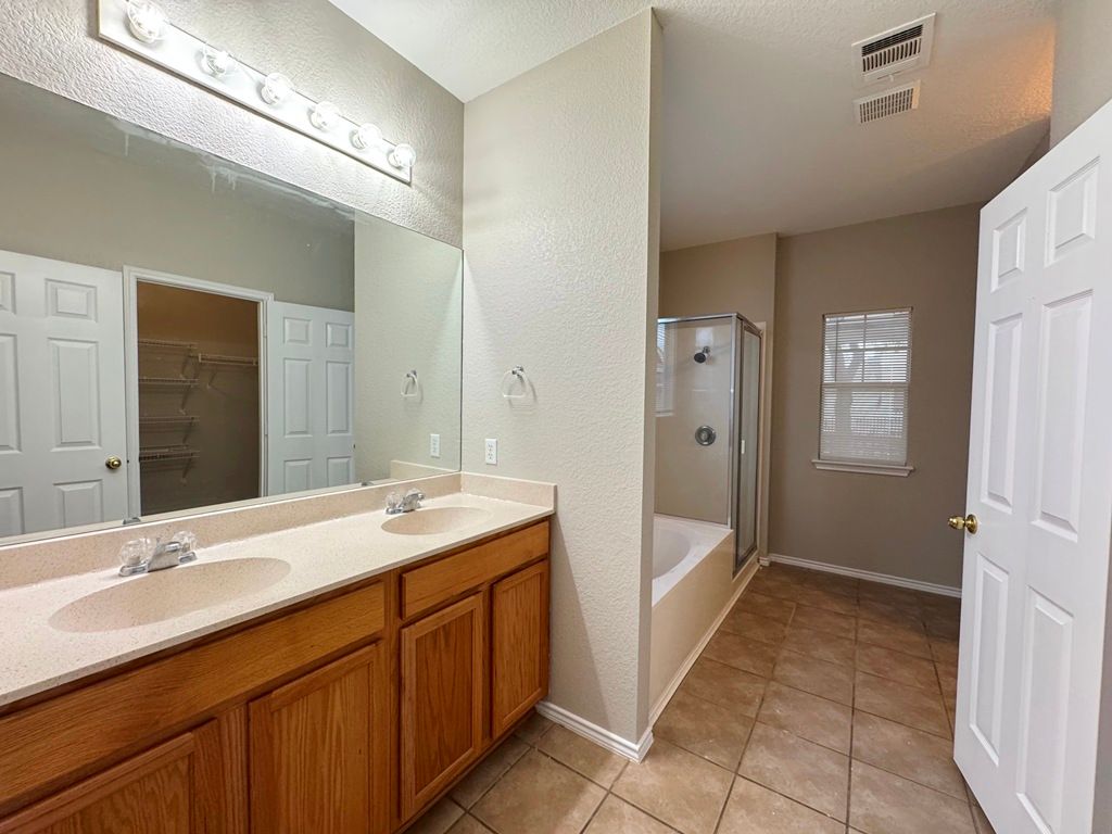 544 Hogan Kyle, TX 78640 - Photo 23 of 40 a spacious bathroom with a granite countertop sink mirror and a
