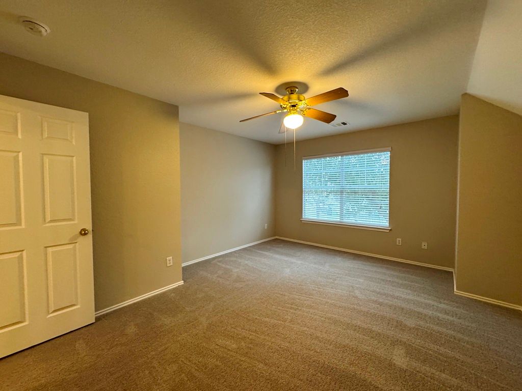 544 Hogan Kyle, TX 78640 - Photo 34 of 40 an empty room with windows and chandelier fan