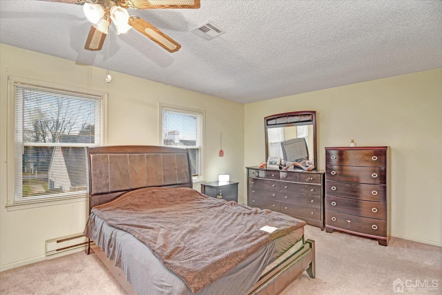 569 Old Nassau Road, Unit O Iselin, NJ 08830 - Photo 15 of 38 a bedroom with a bed and dresser with mirror