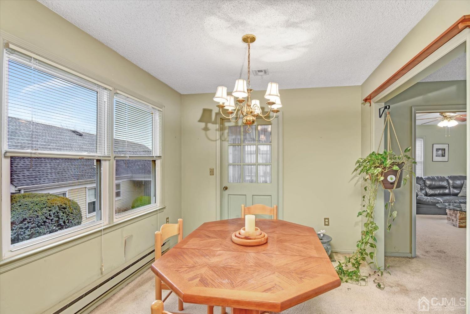569 Old Nassau Road, Unit O Iselin, NJ 08830 - Photo 7 of 38 a dining room with chandelier and outdoor view