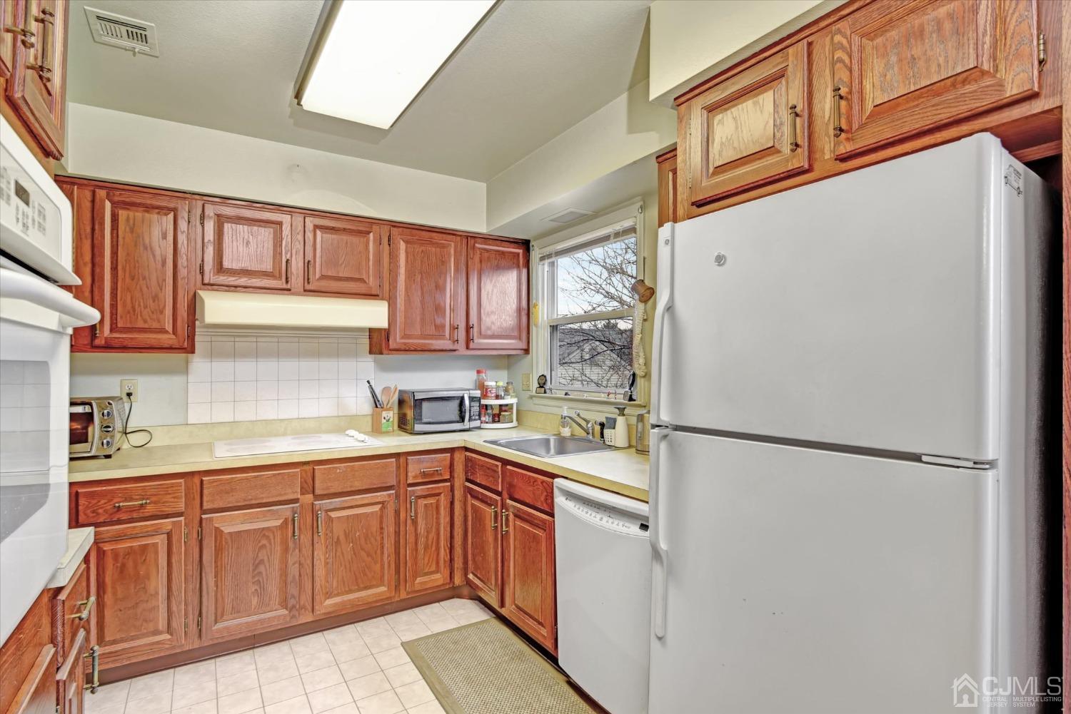 569 Old Nassau Road, Unit O Iselin, NJ 08830 - Photo 9 of 38 a kitchen with stainless steel appliances granite countertop a refrigerator sink and cabinets