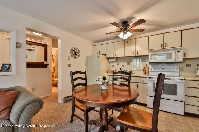 a kitchen with stainless steel appliances a table chairs and a refrigerator