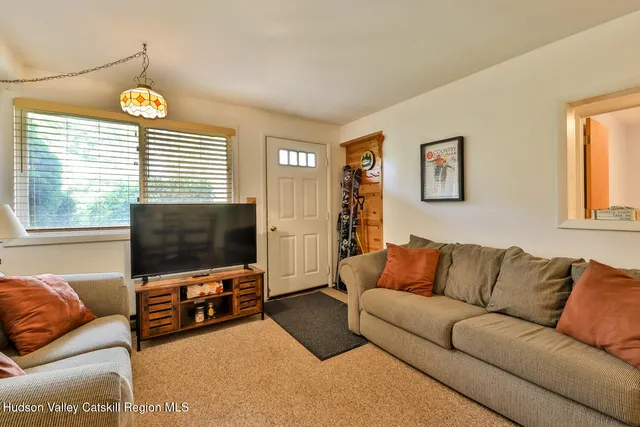 a living room with furniture a flat screen tv and a window