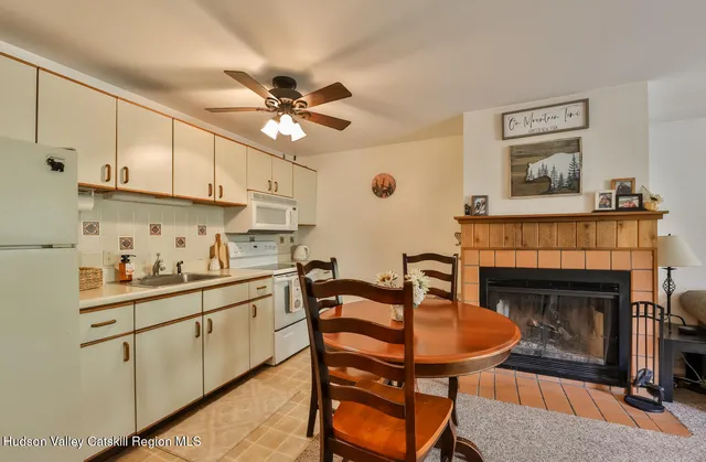 a kitchen with stainless steel appliances a stove a sink cabinets and a fireplace