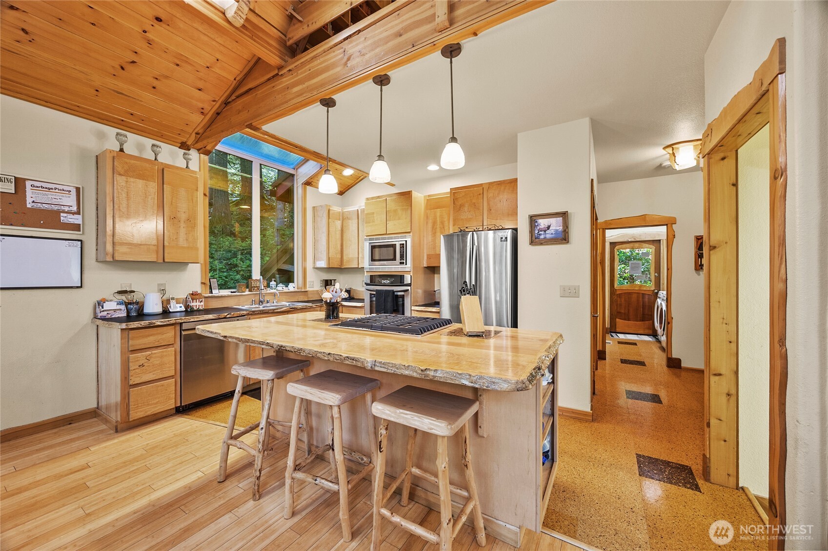 106 Timber Trail Packwood, WA 98361 - Photo 12 of 40 a kitchen with stainless steel appliances granite countertop a table chairs and a refrigerator