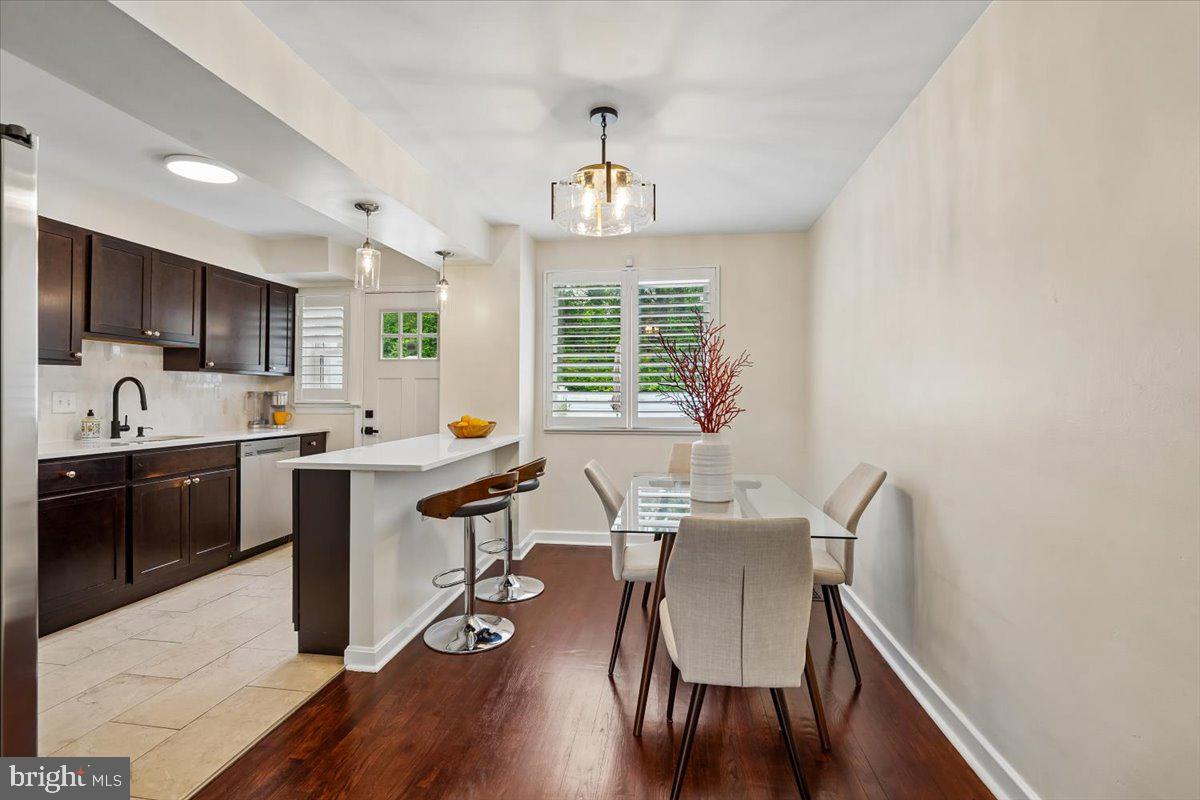 2223 16th Street Northeast Washington, DC 20018 - Photo 13 of 39 a open dining room with kitchen island stainless steel appliances furniture a chandelier and a window