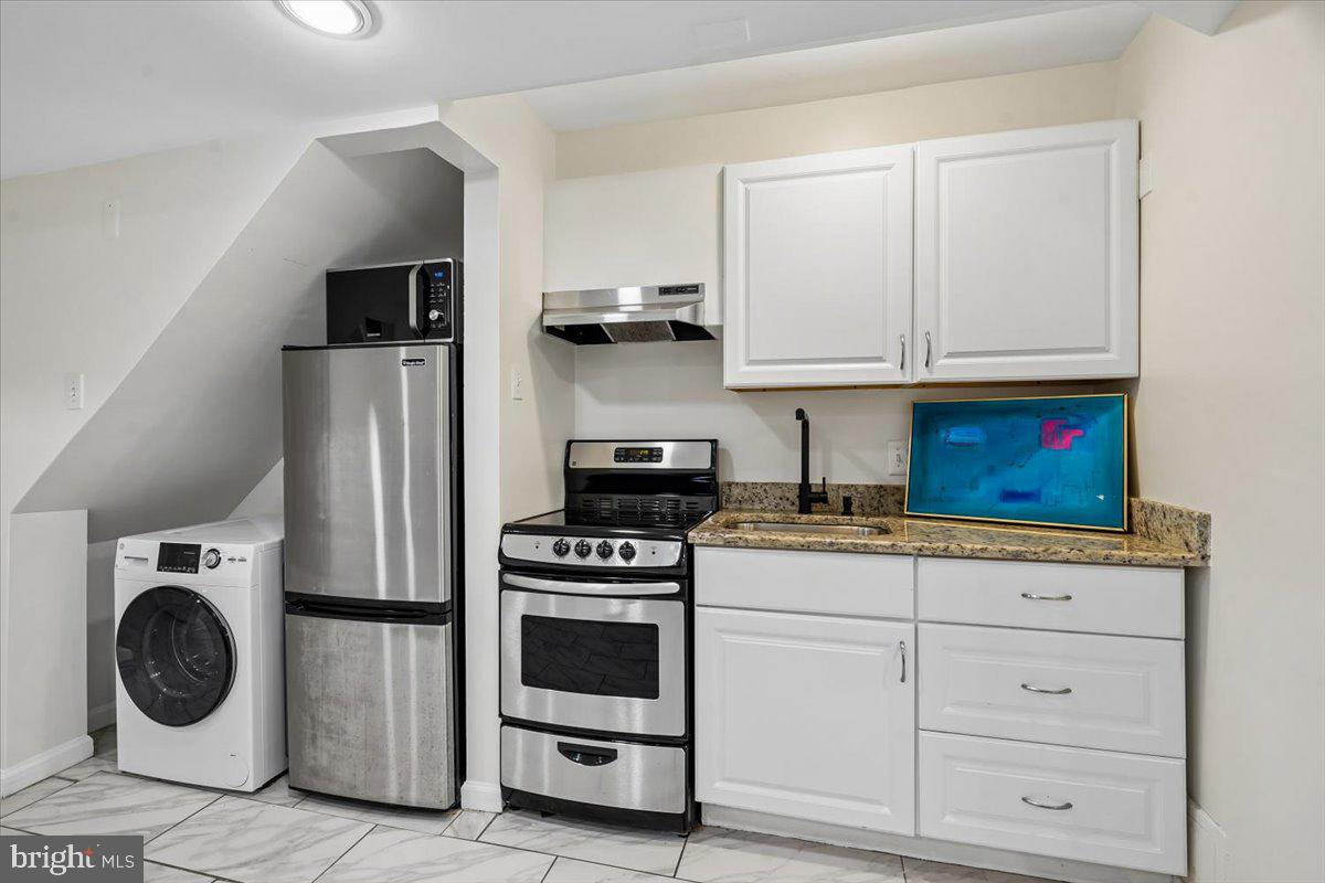 2223 16th Street Northeast Washington, DC 20018 - Photo 35 of 39 a kitchen with stainless steel appliances granite countertop a stove and a refrigerator