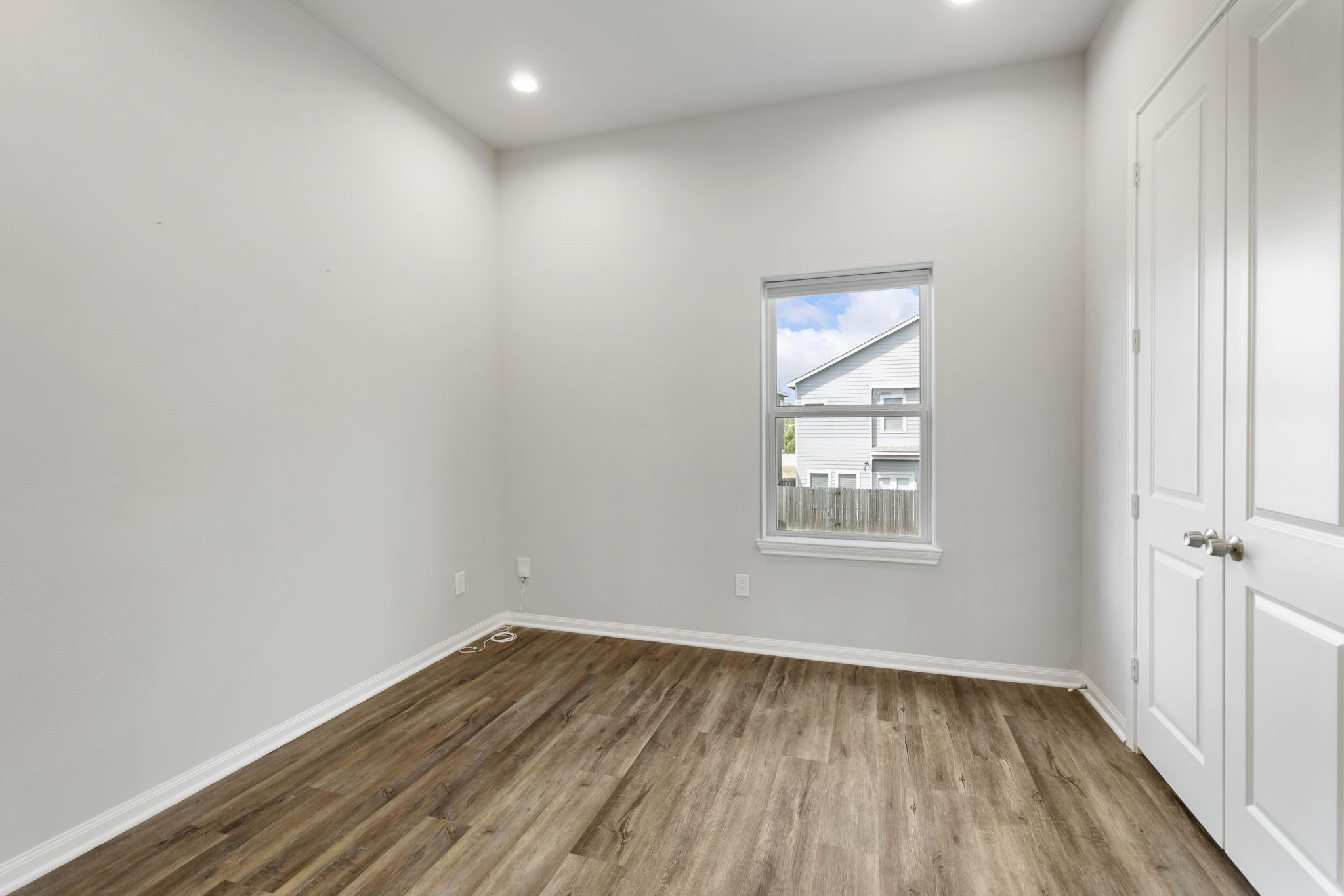 4908 Paradigm Ln Spring Spring, TX 77379 - Photo 8 of 19 a view of an empty room with wooden floor and a window