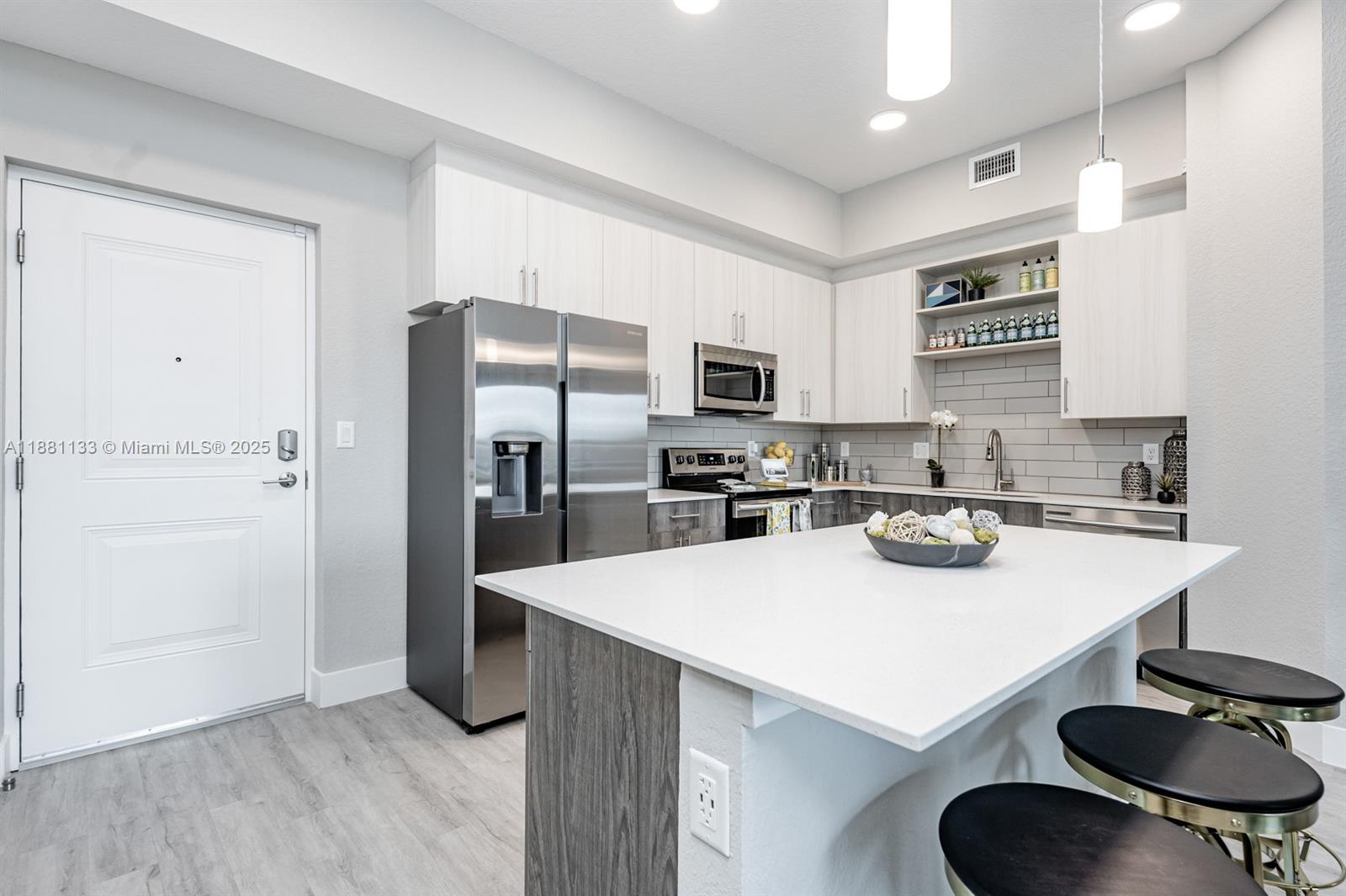 a kitchen with stainless steel appliances a sink and a refrigerator
