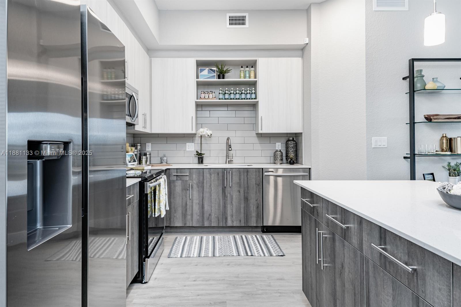 9155 Northwest 57th Street, Unit 103 Tamarac, FL 33351 - Photo 2 of 32 a kitchen with a sink a refrigerator and cabinets