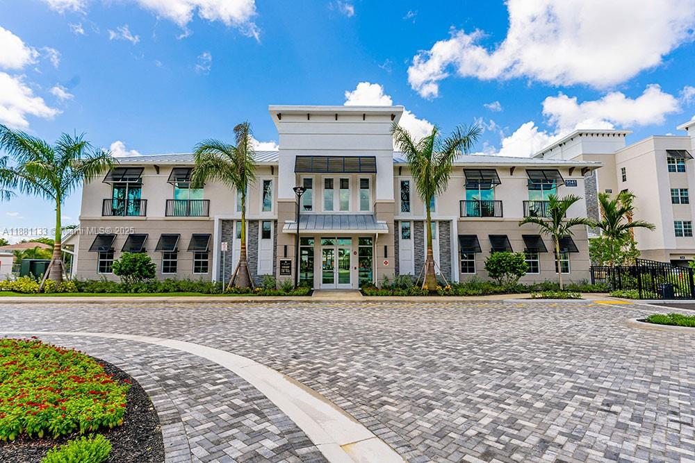 9155 Northwest 57th Street, Unit 103 Tamarac, FL 33351 - Photo 25 of 32 a view of a building with a garden
