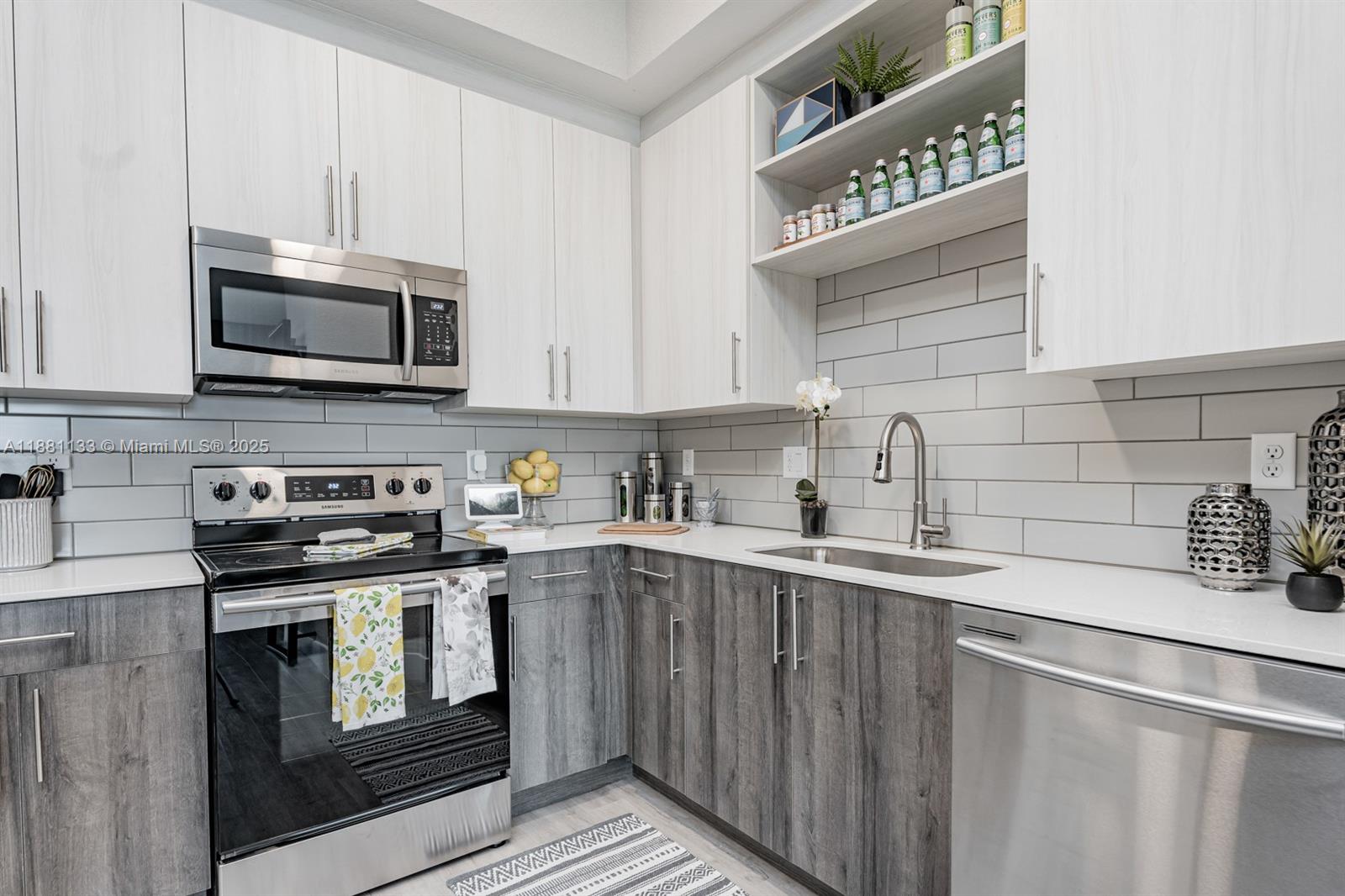 9155 Northwest 57th Street, Unit 103 Tamarac, FL 33351 - Photo 5 of 32 a kitchen with granite countertop a sink a stove and cabinets