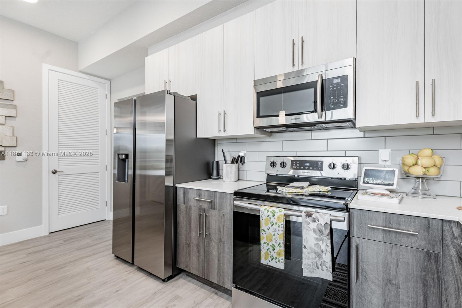 9155 Northwest 57th Street, Unit 103 Tamarac, FL 33351 - Photo 6 of 32 a kitchen with stainless steel appliances a stove a microwave a sink and cabinets