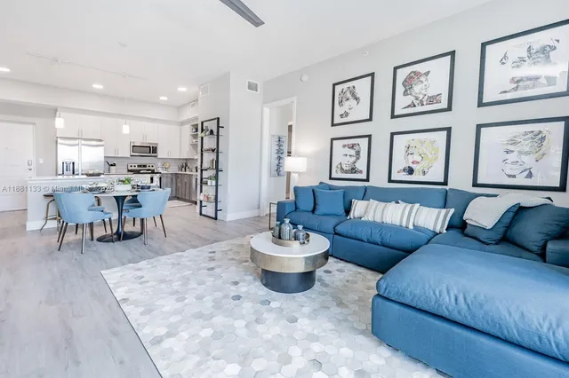 a living room with lots of furniture and view of kitchen
