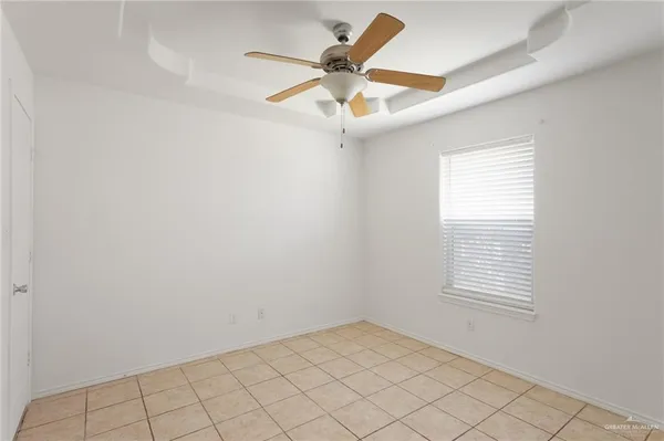 an empty room with a window and a fan
