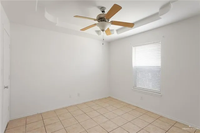 an empty room with a window and a fan