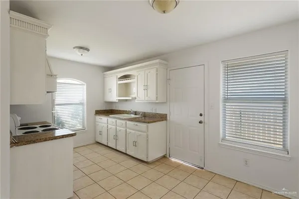 a kitchen with granite countertop white cabinets and white appliances