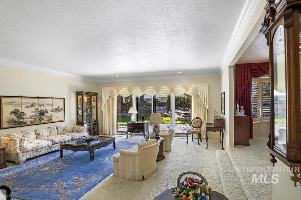 2018 Rancho Vista Drive Twin Falls, ID 83301 - Photo 50 of 50 Spacious living area featuring neutral-toned carpeting, ample natural light, crown molding, a large sliding glass door, and a tiered floor plan