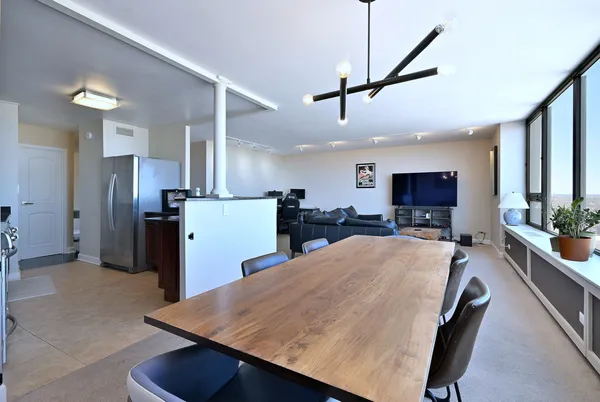 a large kitchen with sink a refrigerator and chairs