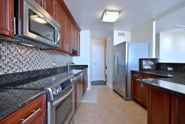 a kitchen with stainless steel appliances granite countertop a sink and cabinets