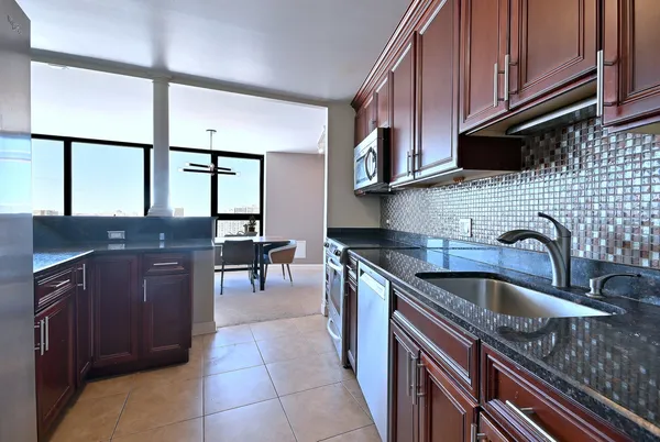 a kitchen with stainless steel appliances granite countertop a stove a sink and a microwave