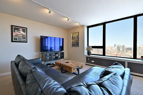a living room with furniture a large window and a flat screen tv
