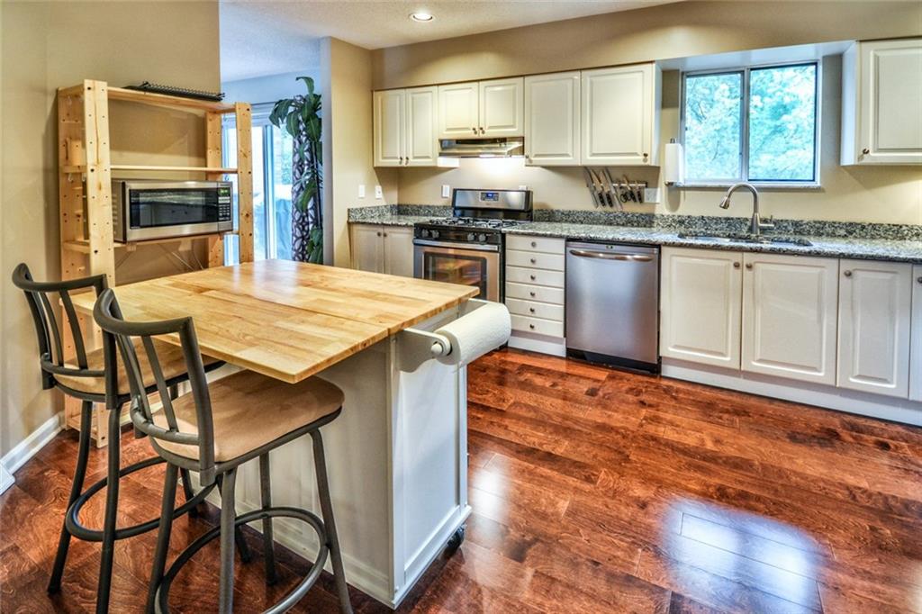 105 Fall Run Road Forest Hills, PA 15221 - Photo 2 of 24 Kitchen with new hardwood floors, granite counters, stainless steel appliances and a portable island.